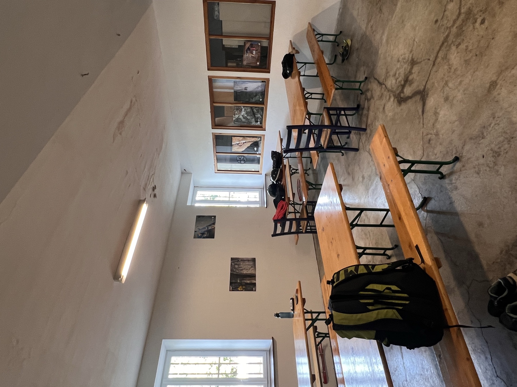 Espace table avec banquettes en bois et hautes fenêtres
